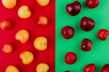 top view of ripe red and yellow cherries isolated on red and green background