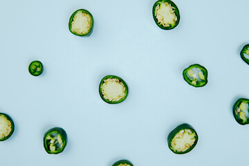 top view of sliced green chili peppers isolated on blue background