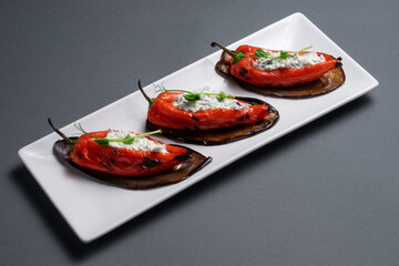 closeup of bulgarian peppers stuffed with cottage cheese on black background