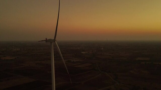 Aerial view over the farm landscape and wind turbines generating clean renewable energy. Renewable energy production for the green ecological world.