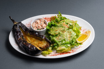 closeup of baked eggplant with chinese cabbage and sauce on black background