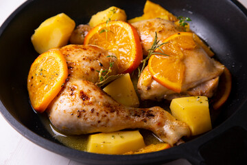 Chicken cooked with potatoes and orange sauce.