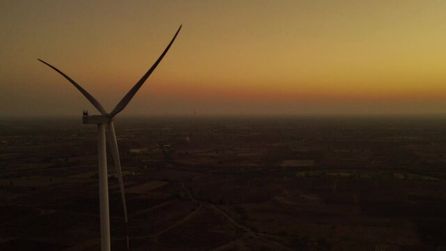 Aerial view over the farm landscape and wind turbines generating clean renewable energy. Renewable energy production for the green ecological world.