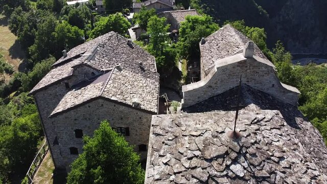 Europe, Italy , val Trebbia, Bobbio, drone aerial view of roofs of slate stone houses in Brugnello, a small abandoned village with church and stone houses 