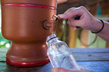 Enchendo garrafa de água em filtro de barro
