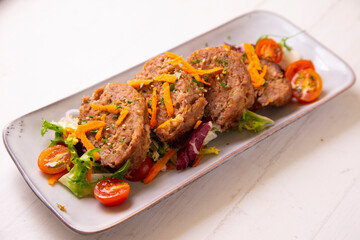 Meat roll with salad. Cooked in the oven. Traditional northern Spanish dish.