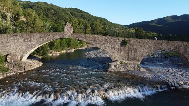 Europe, Italy , Bobbio , Piacenza ,Val Trebbia- Drone aerial view of roman historic stones bridge Ponte Gobbo o Ponte Vecchio and Bobbio village 
