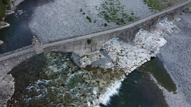 Europe, Italy , Bobbio , Piacenza ,Val Trebbia- Drone aerial view of roman historic stones bridge Ponte Gobbo o Ponte Vecchio and Bobbio village 