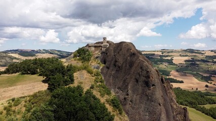 Europe, Italy, Travo , Drone aerial view in Pietra Perducca, volcanic rock with  church set in stone immersed in a  countryside landscape with cultivated land in Val Trebbia Bobbio