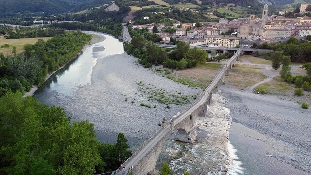 Europe, Italy , Bobbio , Piacenza - Drone aerial view of roman historic stones bridge Ponte Gobbo o Ponte Vecchio pass over  the river Val Trebbia