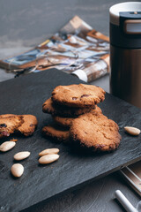 Steel thermo coffee bottle on gray concrete background with macaroons and smartphone. Tinting