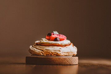 Torta Pavlova sobre textura madera. torta con iluminación lateral