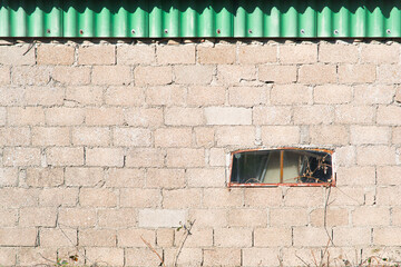 un vieux mur et une petite fenêtre rectangulaire.