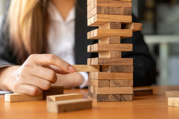 A businesswoman pulls a wooden block in the middle of the floor. It is like managing business risks with strategies. and project management the best of the business