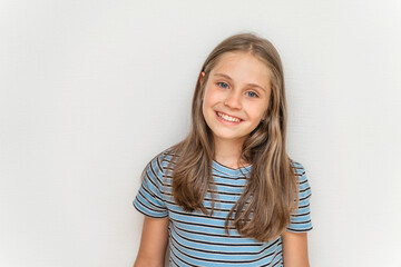 Portrait of a smiling little girl child with long blonde hair on a white background