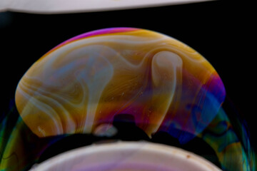 closeup photo of colored light reflection on the surface of soap bubble