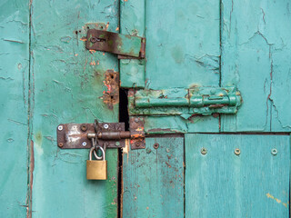 Vintage security, ancient bolts and a padlock close this old door.