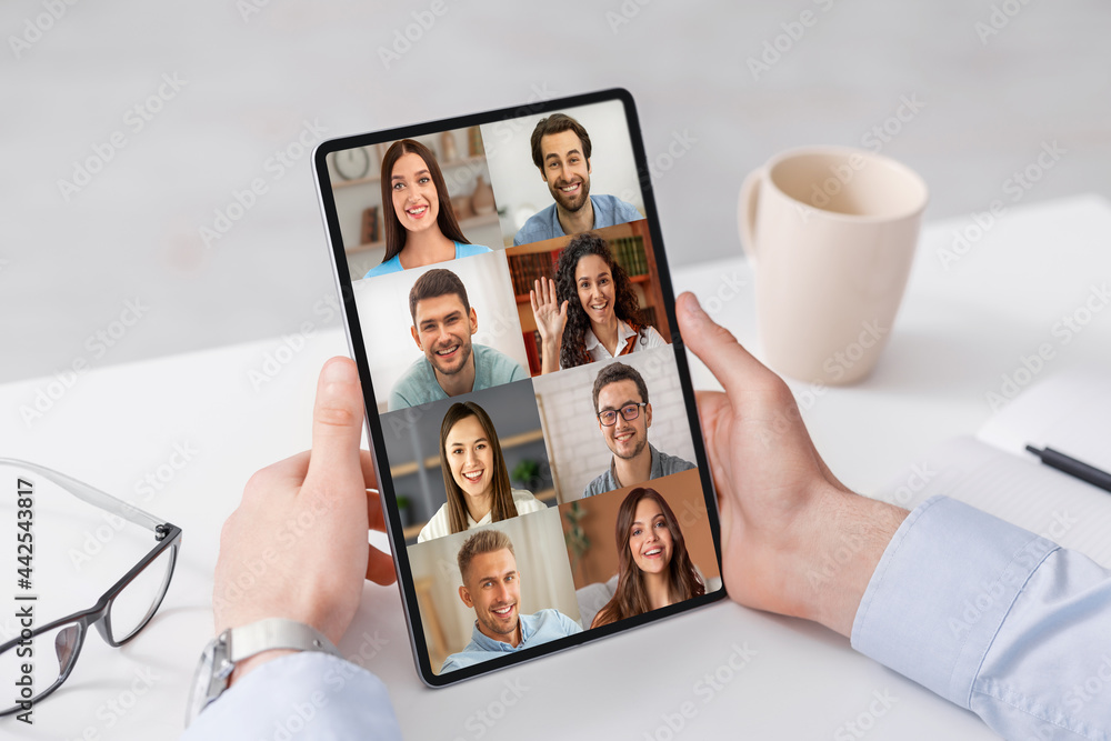 Poster unrecognizable man using digital tablet in office for video call with colleagues