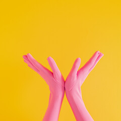 hands with pink glove on yellow sunny summer background. modern summer abstract art. mimalism