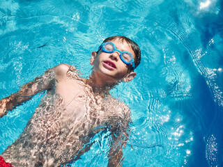 Naklejka premium young boy swimming on a swimming pool. close up look