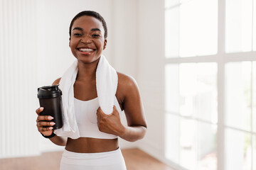 Portrait of sporty beautiful smiling black woman in white sportswear
