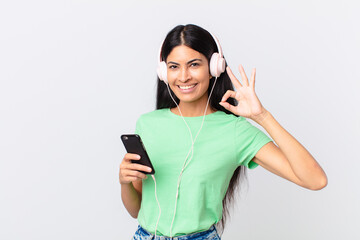 hispanic pretty woman with headphones and a smarphone