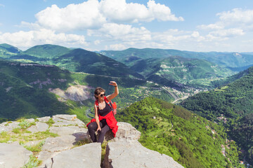 Fototapeta premium Tourist Woman with Backpack on the Top of Summer Mountain with Stunning View. Summer Mountain in Bulgaria ,Bov Village ,Balkan Mountain ,Iskar Gorge