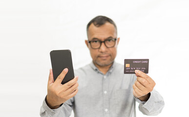 Male shoppers holding smartphones and credit cards. Concept for mobile, phone, casual, smartphone, shopping, smile, happiness, payment. Copy space on left and right. Selective focus. White background
