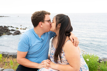 couple in love kissing each other while spending time outdoors on seaside
