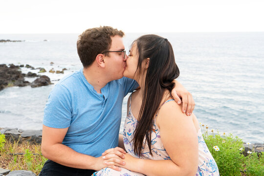 couple in love kissing each other while spending time outdoors on seaside