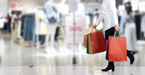 Woman holding shopping bag in mall on black Friday