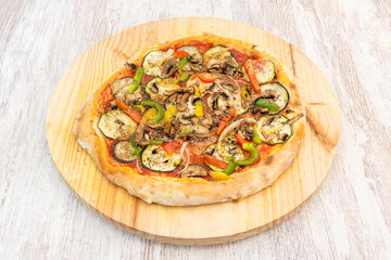 Great vegan pizza with many kinds of vegetables and mushrooms with wheat flour dough on wooden board