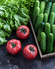 Fresh red tomatoes and cucumbers with salad. Fresh vegetables in the box