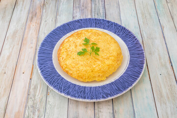 Blue border plate with small Spanish omelette to share in a tapas restaurant