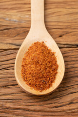 Closeup of cayenne pepper on a spoon over wooden table