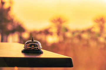 Hotel service bell against the background of coastline sea and palm tree on sunset. Travel concept....