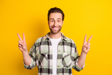 Photo of young cheerful man happy positive smile show peace cool v-sign isolated over yellow color background