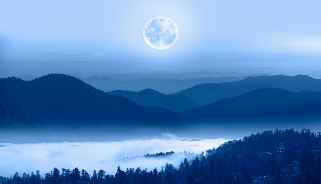 Beautiful landscape with blue misty silhouettes of mountains against super blue moon rising "Elements of this image furnished by NASA"