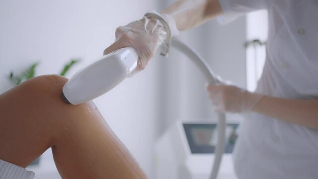 Laser epilation and cosmetology in beauty salon. Cosmetology, spa and hair removal concept. Laser hair removal procedure of female legs. doctor in gloves.