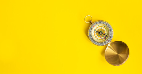 Compass on a yellow surface with copy space for text