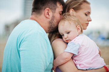 Summer vacations. Parents and people outdoor activity with children. Happy family holidays. Father, pregnant mother, baby daughter on sea sand beach.