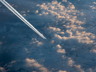 View from the window of a flying plane on the flight of another plane, clouds, earth, sun