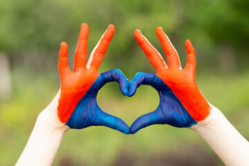 Love Mongolia concept. Little girl show hands in heart form painted in Mongolia flag color. Mongolian patriotism. July 10 National Flag Day. Mongolian independence holiday 29th of December. January 13