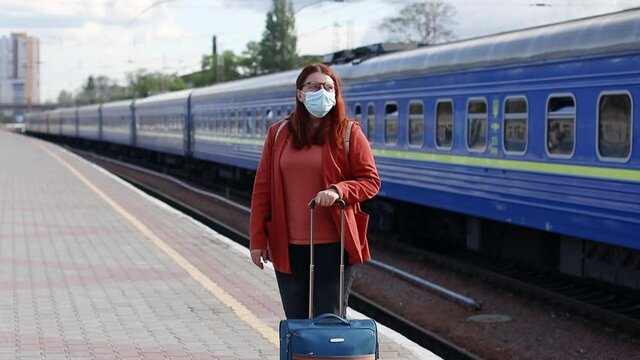 Flu disease virus spreading protection mask protective against influenza viruses and diseases. Portrait of Caucasian woman tourist protective face mask outdoors at the train station
