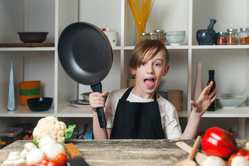 Child at cooking classes. Boy wearing chef apron. Kid dreaming of future profession.