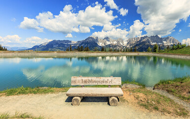 Famous wooden bench Lieblingsplatzl at the Astbergsee lake on the Astbergalm in Going at the Wilder...