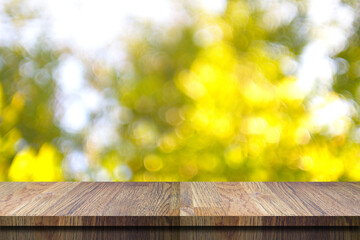 Empty wood table with blurred  yellow  leaves background use as background montage and presentation.