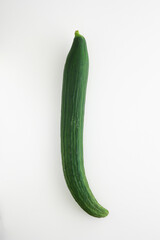 One whole unpeeled fresh green long cucumber isolated on white background top view