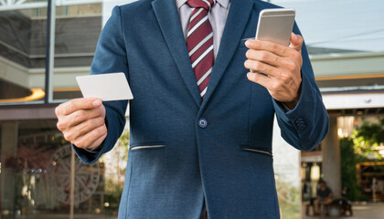 Businessman showing blank business card and holding smart phone..Business man holding white blank card space for text. product display montage.