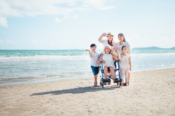 Family happily chatted with Grandma on the beach wheelchair.